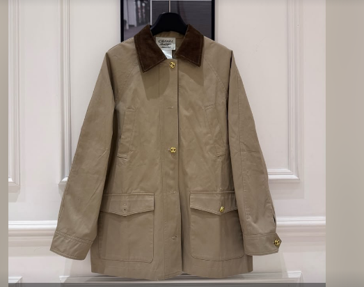 Beige wool jacket with dark fur collar and gold buttons displayed on a hanger