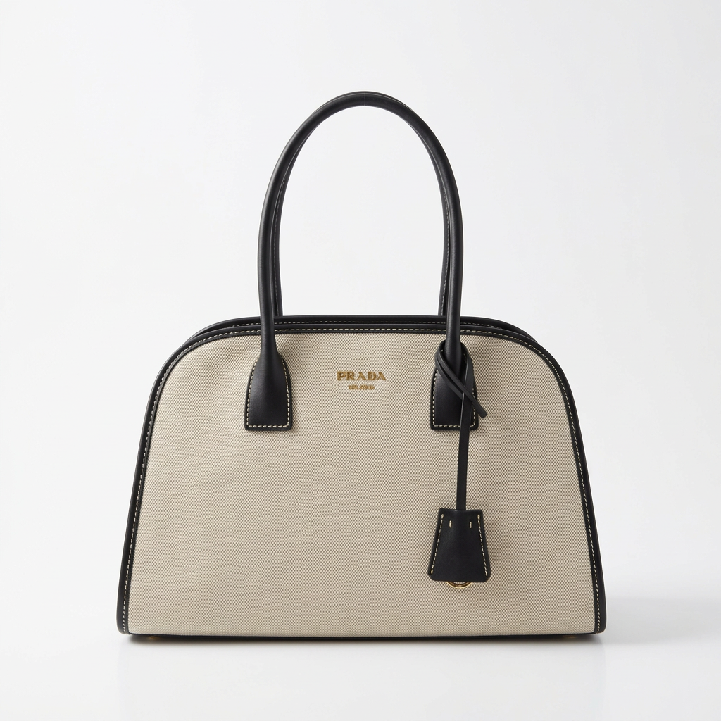 Cream canvas tote bag with black leather trim, studio shot on white background