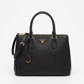 Black saffiano leather tote bag with gold hardware, studio shot on white background