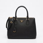 Black saffiano leather tote bag with gold hardware, studio shot on white background